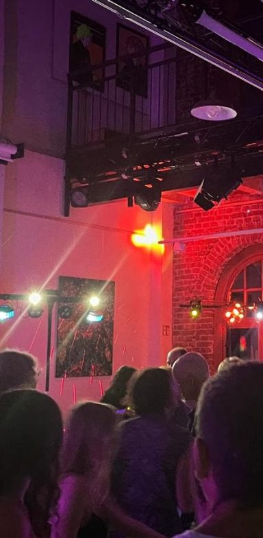 Bunte Lichter und Menschen, die in einer lebhaften Atmosphäre tanzen.